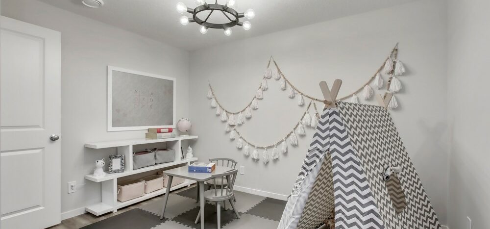 A grey room with a child-size tent, table, chair, and shelving.