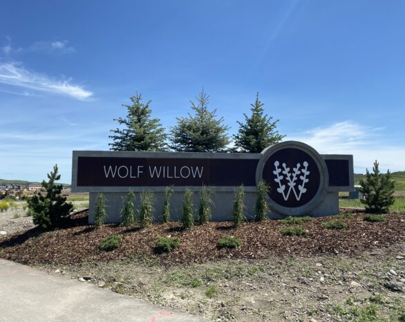 A concrete sign of the Wolf Willow logo and wordmark.