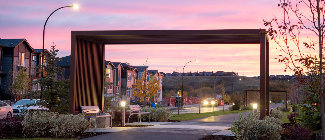 Wolf Willow Promenade Park at sunset in summer with a pink sky.