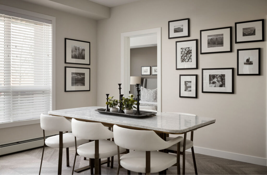 a dining area in a truman condo with a glasstop table, four chairs, and collage style art on the wall