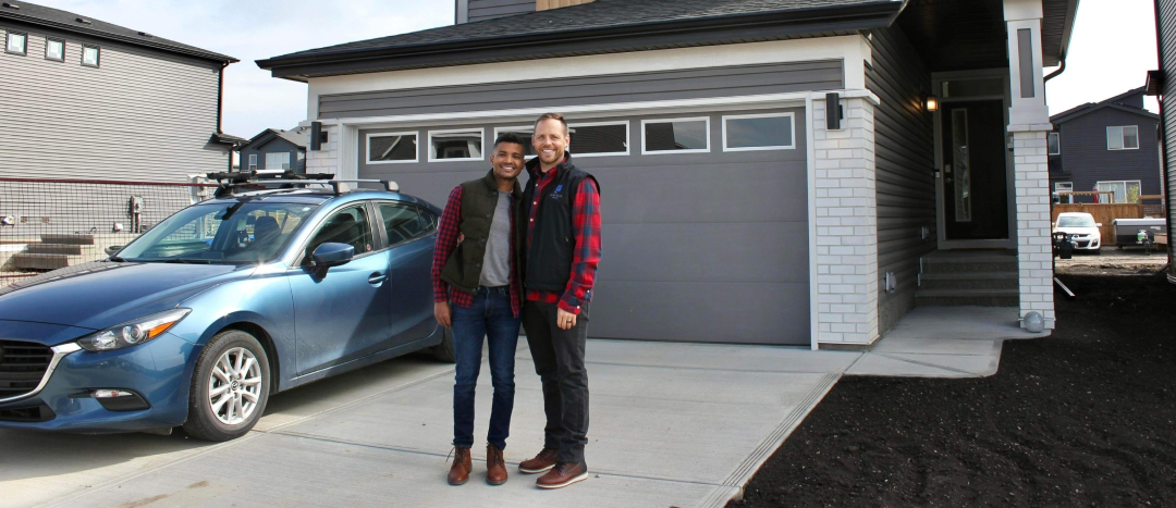 a happy couple standing outside of their new jayman front garage home