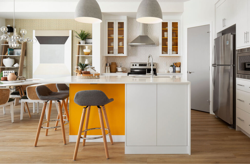 light kitchen with grey bar stools, white cabinetry, and bright orange accents