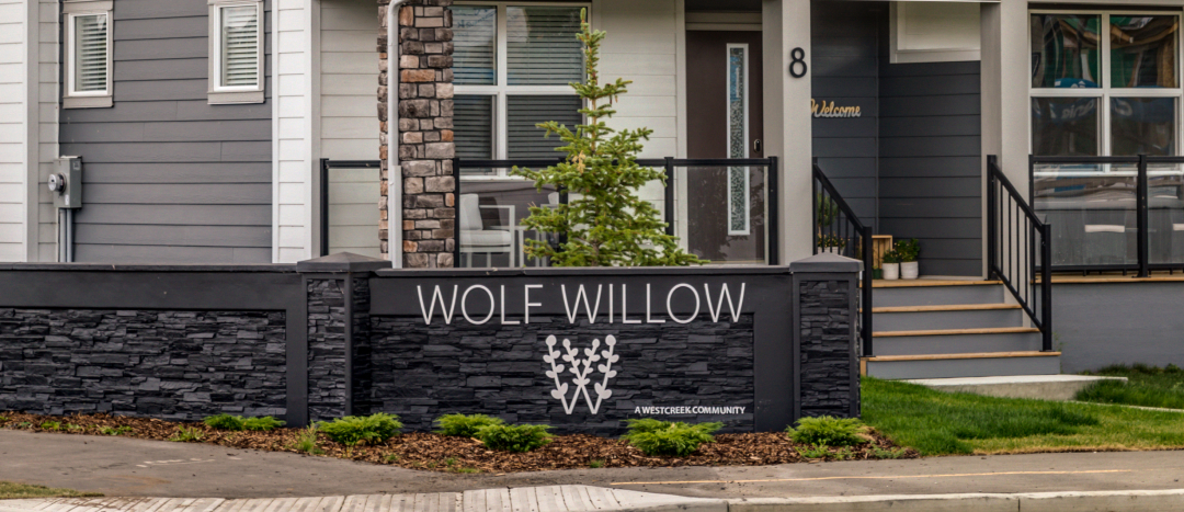 new "wolf willow" sign on a wall near the entrance to the community